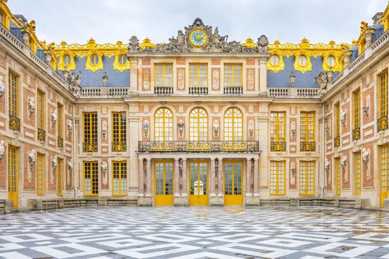 Marble Courtyard of Versailles palace with black-and-white checkered paving and gilded balconies
